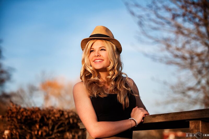 woman in hat smiling outdoors