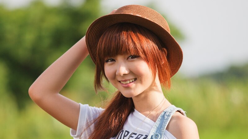 woman in hat smiling outdoors