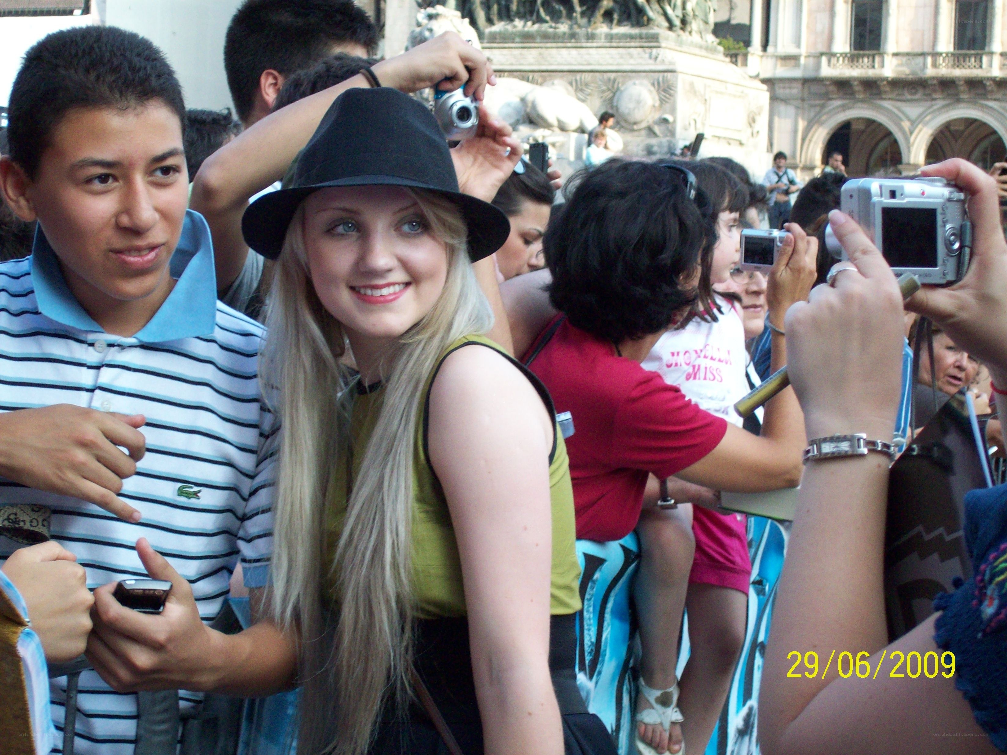 woman in hat surrounded by crowd