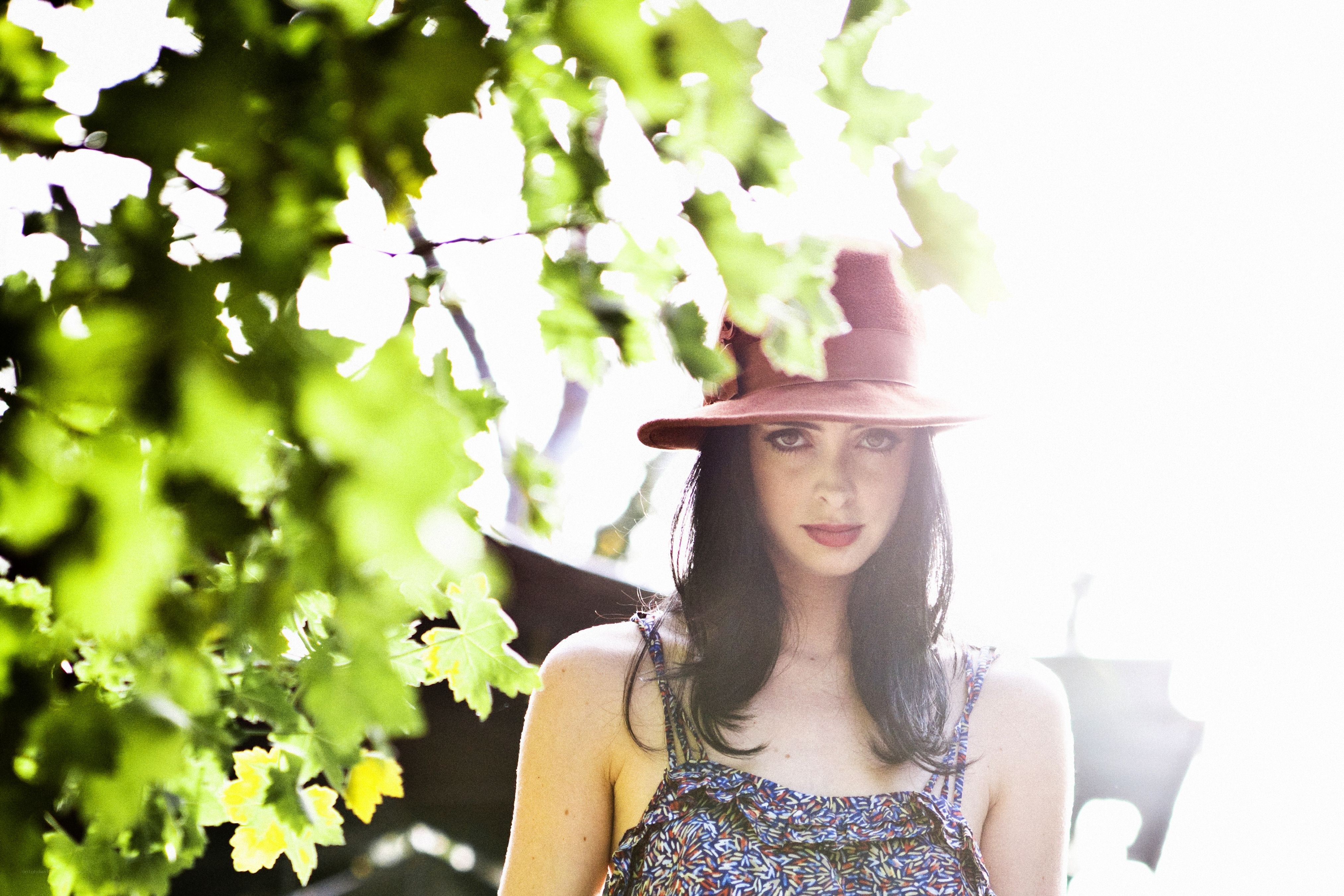 woman in hat under tree