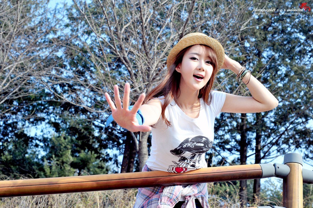woman in hat waving at camera