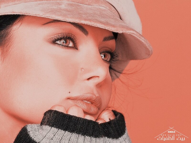 woman in hat with hand on chin