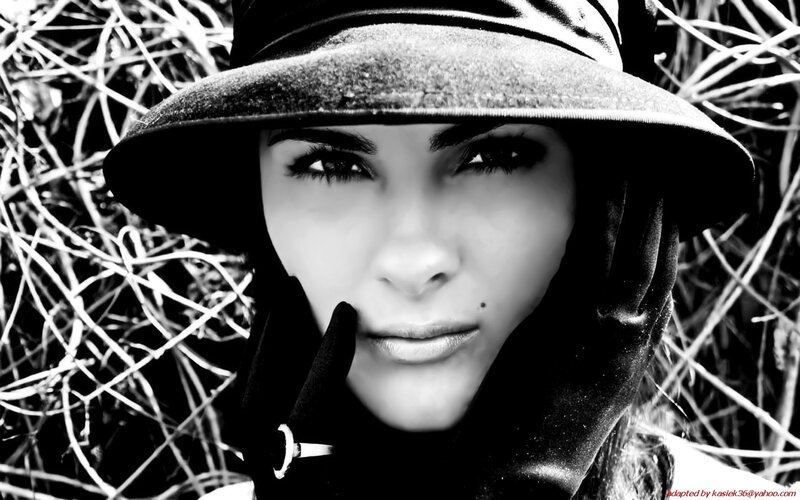 woman in hat with hand on face