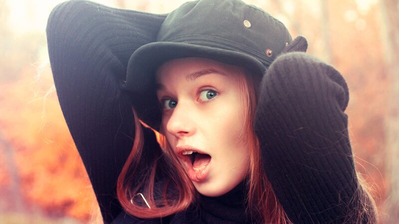 woman in hat with surprised expression