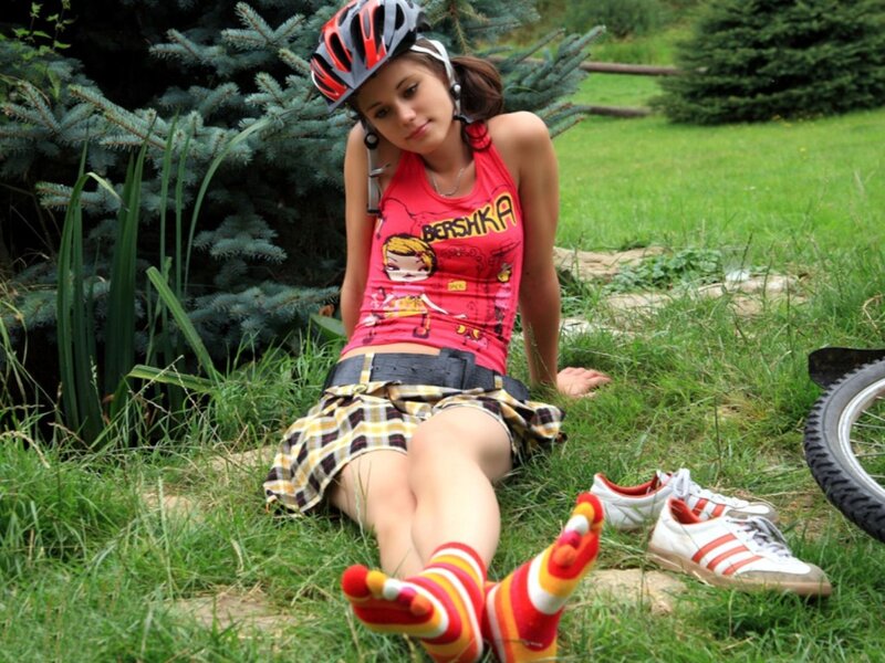 Woman in helmet sitting on grass