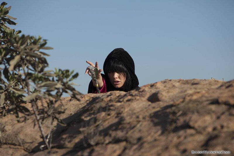 woman in hood holding object