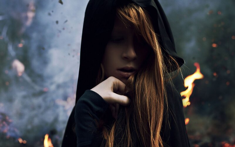 woman in hood with fire