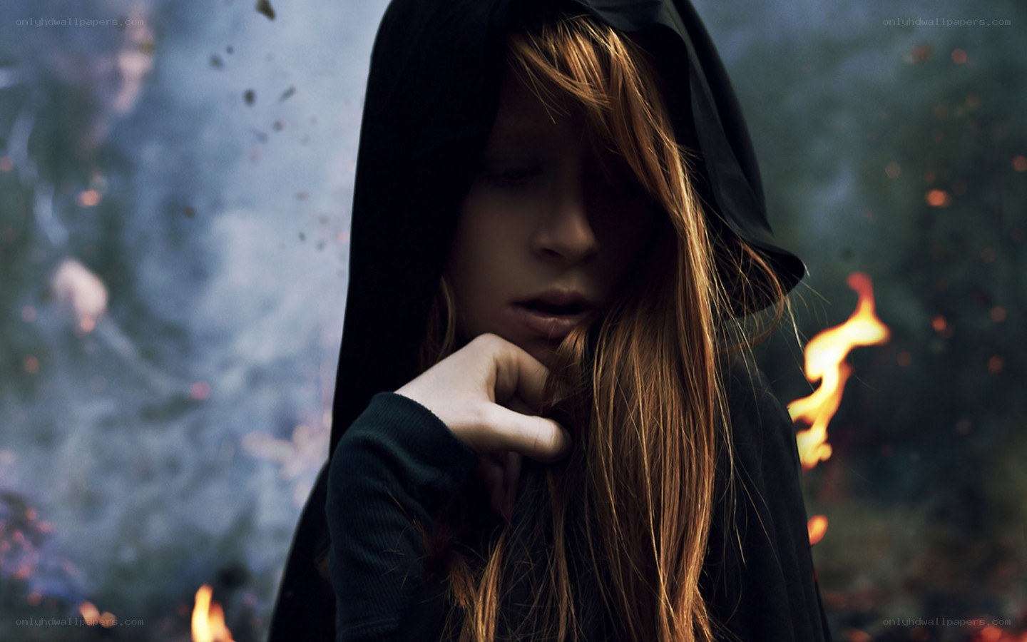 woman in hood with fire