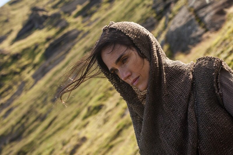 woman in hooded cloak on hillside
