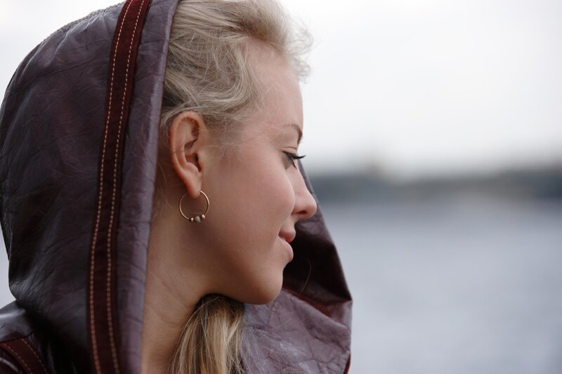 Woman in Hooded Jacket — Brown, Contemplative, Photograph
