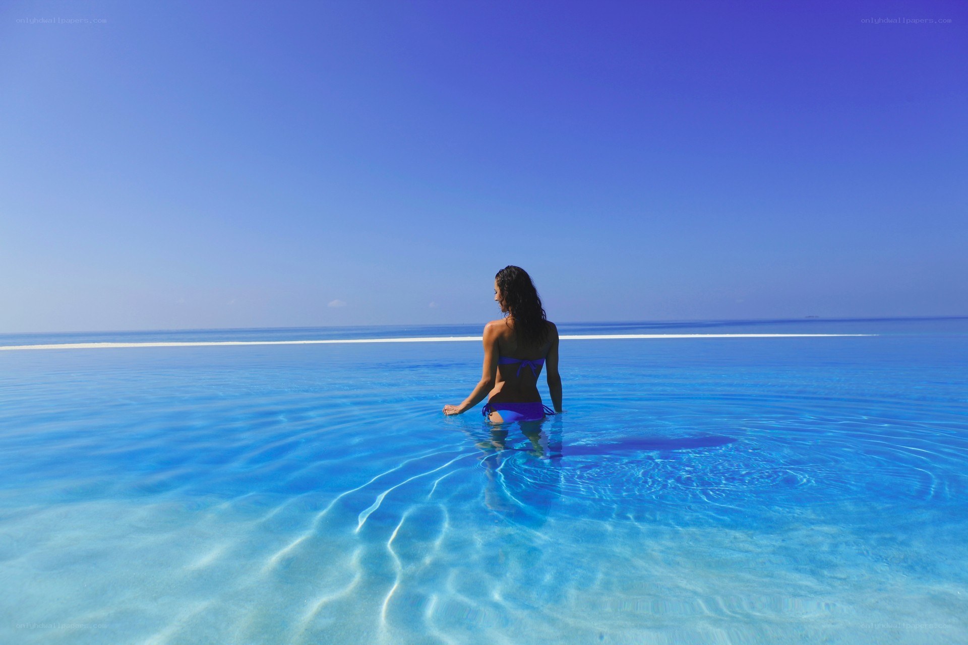 Woman in infinity pool at beach