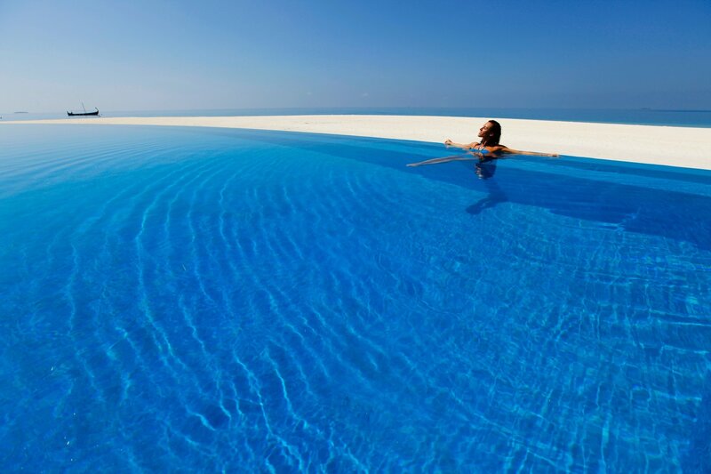 Woman in Infinity Pool — Blue, Serene, Afternoon, Photograph, Beach