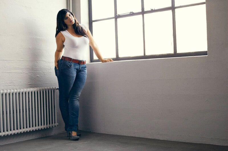 woman in jeans by window