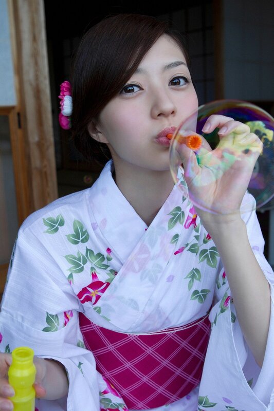 Woman in kimono blowing bubbles