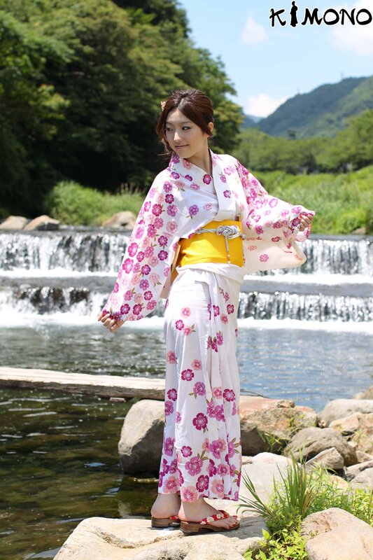 Woman in kimono by a waterfall