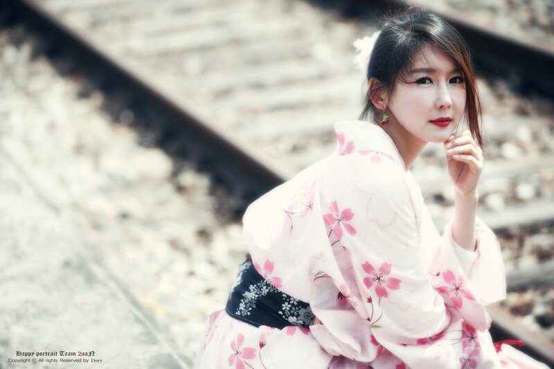 woman in kimono by train tracks