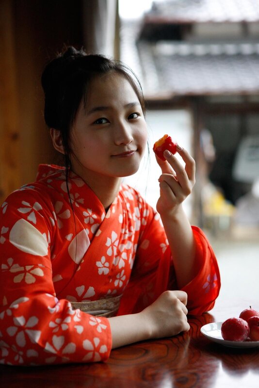 Woman in kimono holding fruit