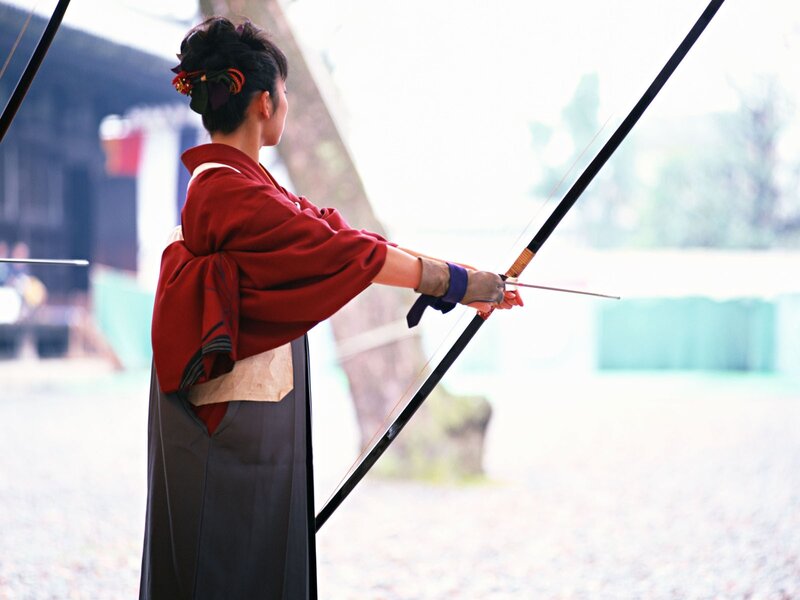 Woman in kimono shooting bow