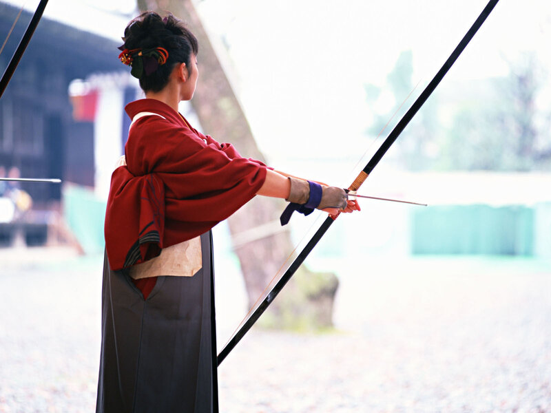 Woman in kimono shooting bow