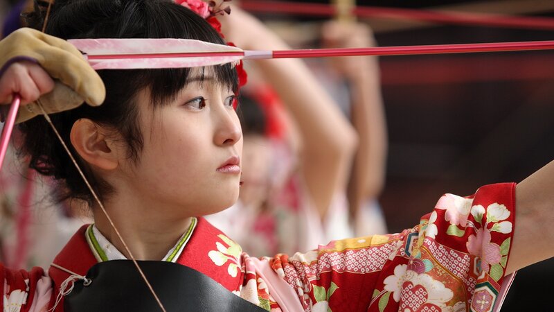 Woman in kimono shooting bow