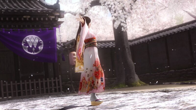 Woman in kimono under cherry blossoms