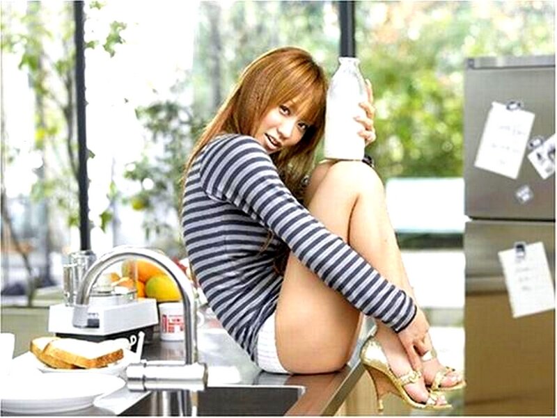 Woman in kitchen with milk bottle