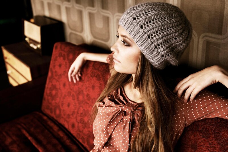 woman in knit hat on red couch
