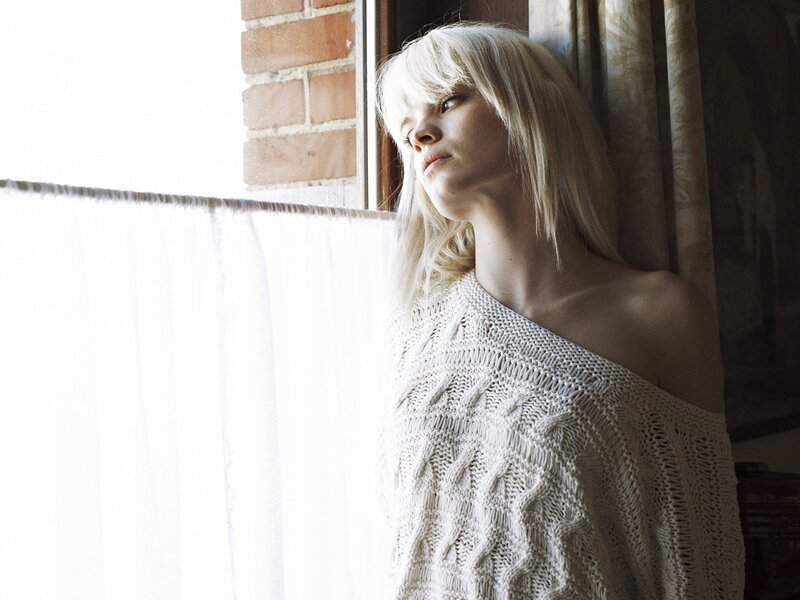 Woman in knit sweater by window