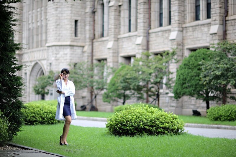 woman in lab coat on campus