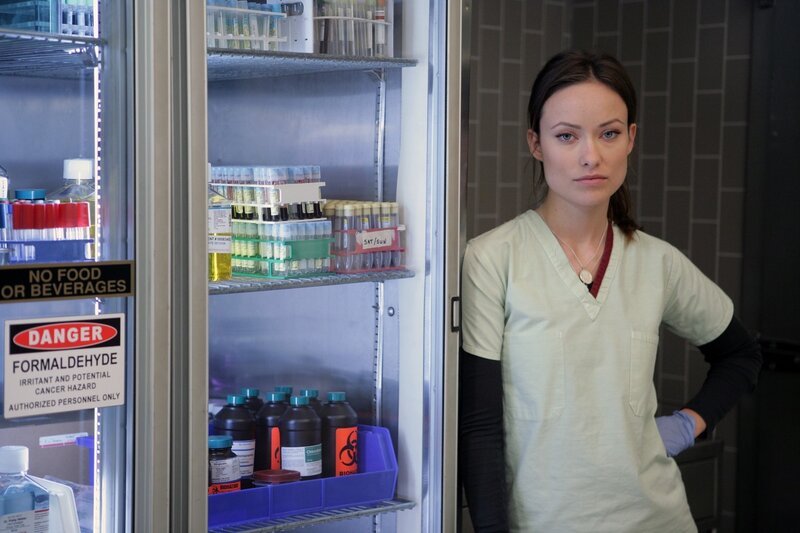 Woman in lab near refrigerator