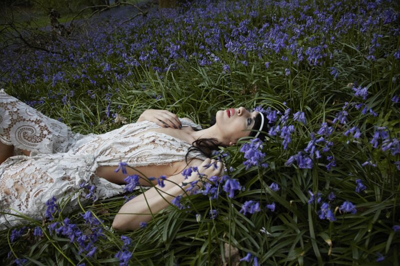 Woman in lace dress among bluebells