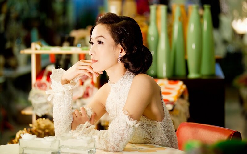 woman in lace dress at table