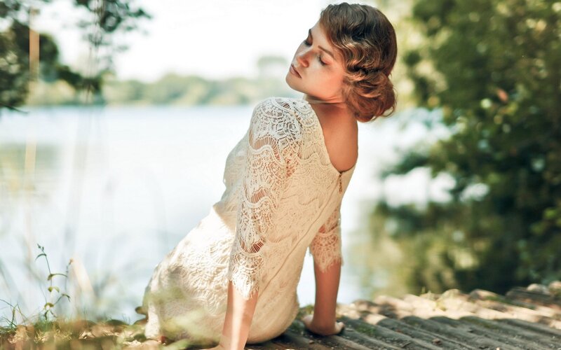 woman in lace dress by lake