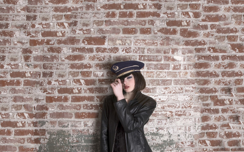 woman in leather jacket and cap