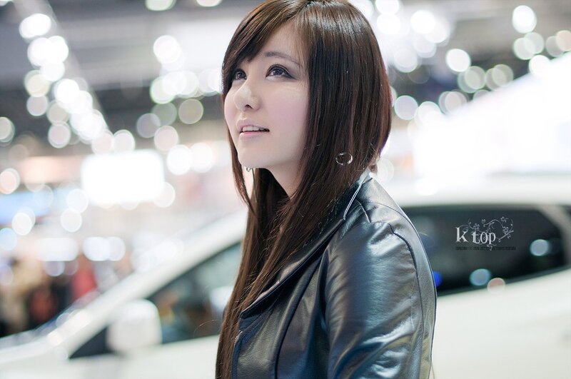 woman in leather jacket at car show