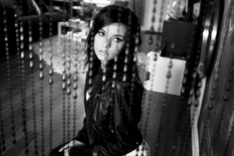 woman in leather jacket behind beads