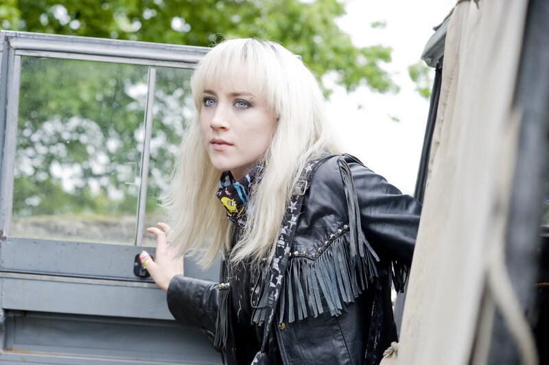 woman in leather jacket by vehicle