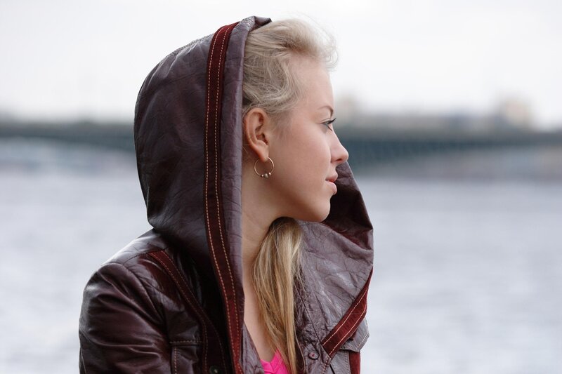 woman in leather jacket by water