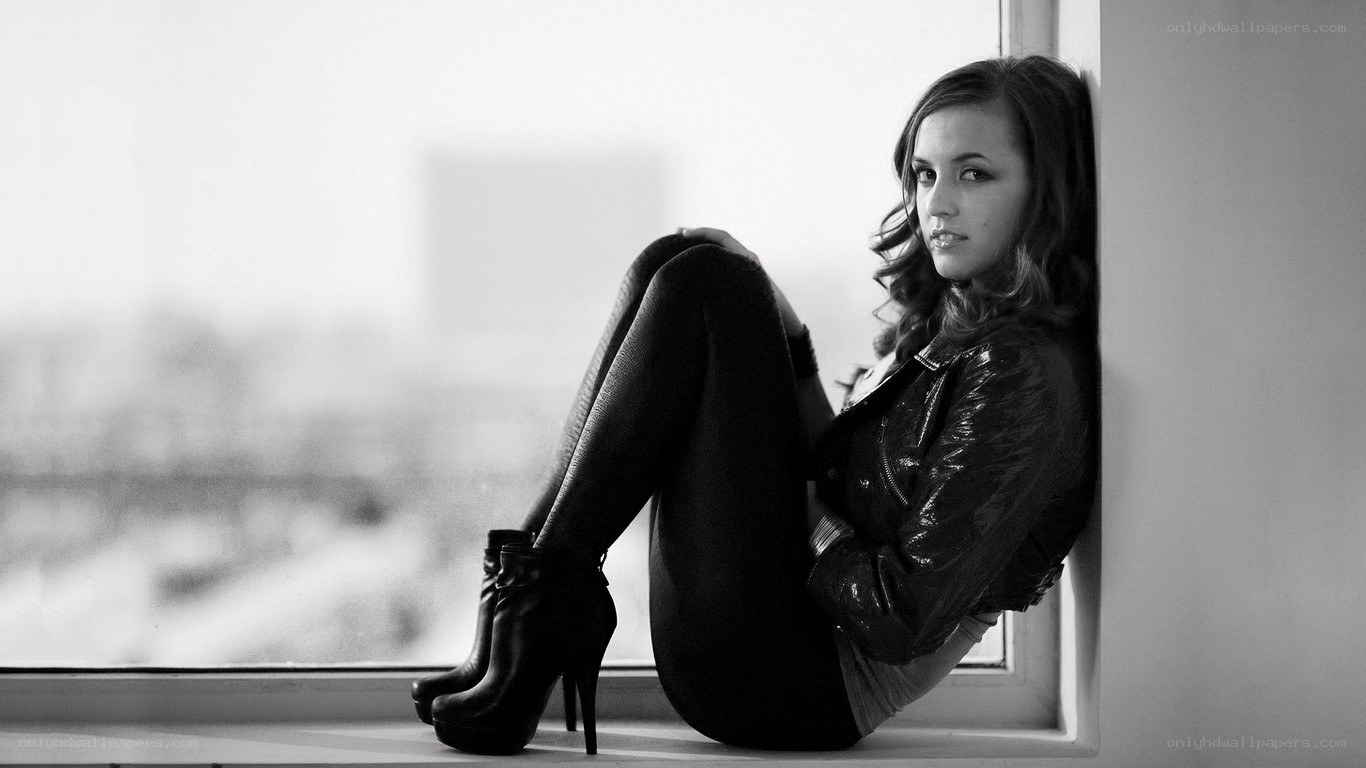 woman in leather jacket by window