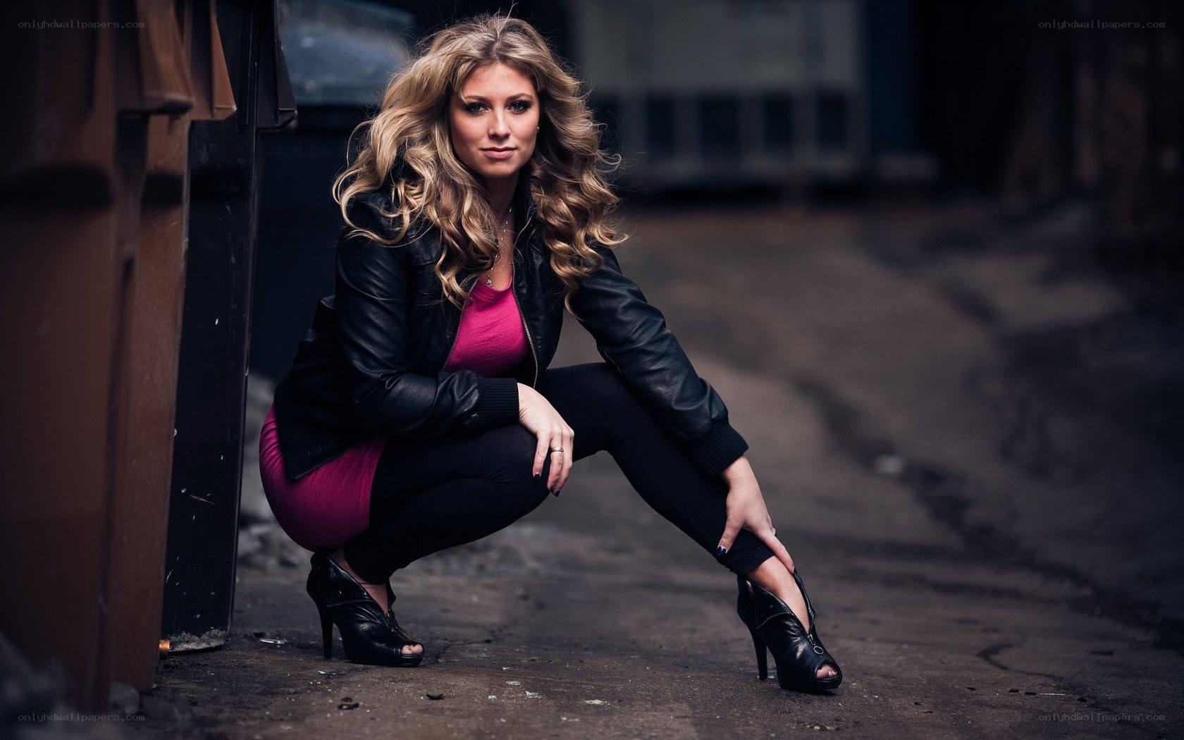 woman in leather jacket crouching