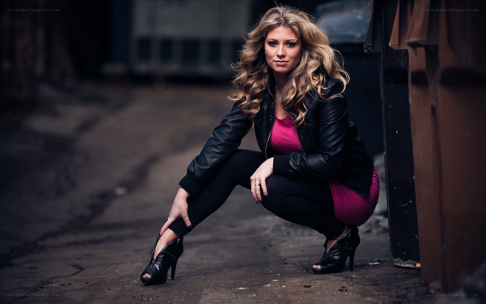 woman in leather jacket crouching