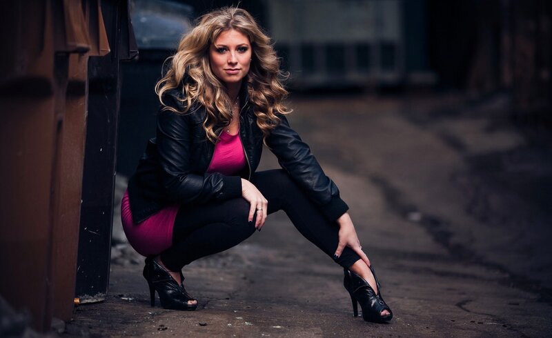 woman in leather jacket crouching