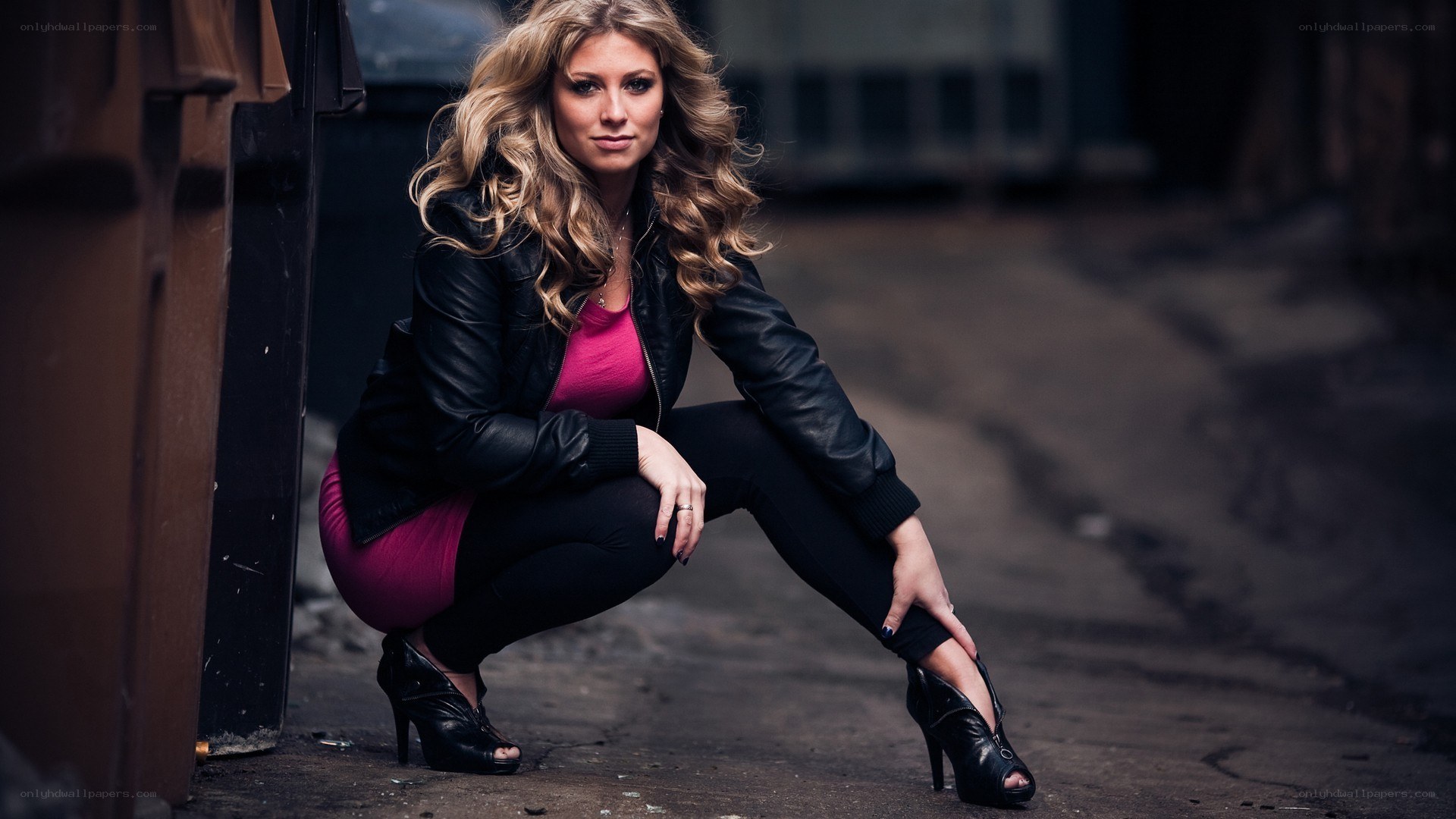woman in leather jacket crouching