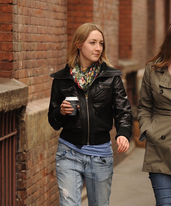 Woman in leather jacket holding coffee
