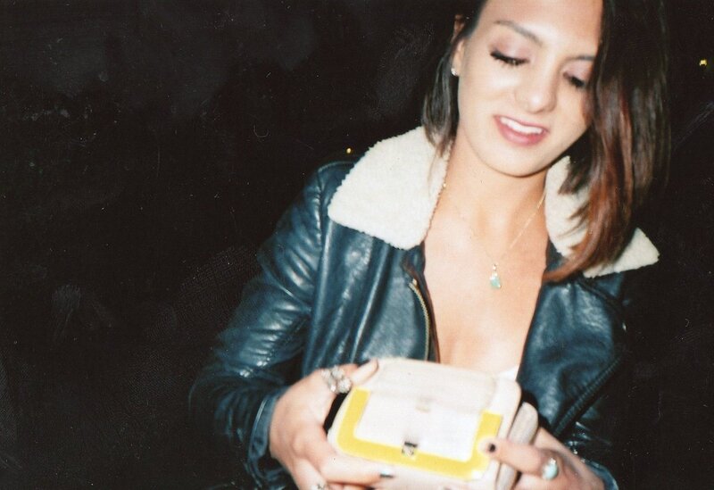 woman in leather jacket holding wallet