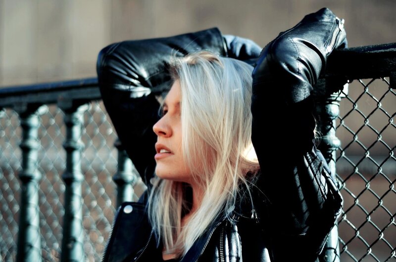 woman in leather jacket leaning
