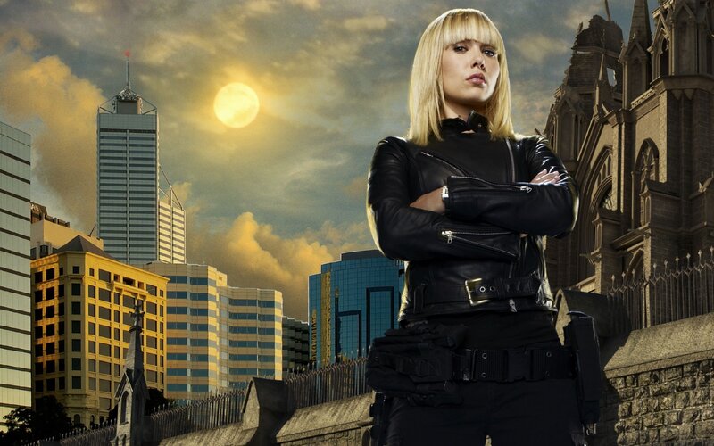 Woman in leather jacket on city rooftop