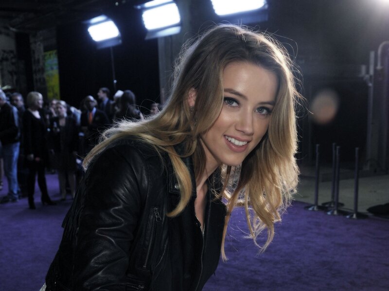 woman in leather jacket on purple carpet