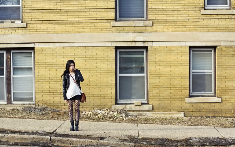 woman in leather jacket on sidewalk