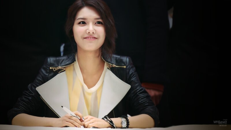woman in leather jacket signing
